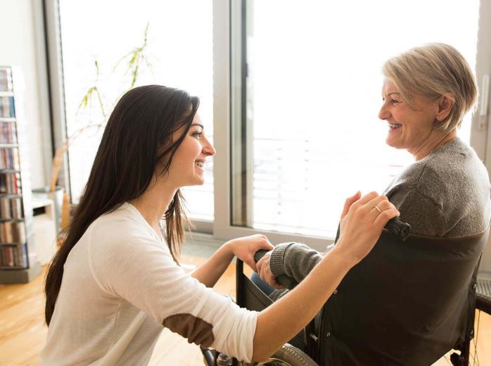 woman smiling with woman in wheelchair