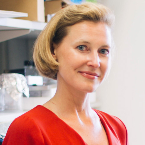 Photo of Christine, a middle-aged white woman with blonde hair in a short bob. She is smiling and wearing a red top.